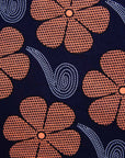 Close up Display of navy dress with brown flowers and white swirls, fabric.