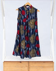 Display of navy sleeveless dress with red, yellow and white splatter print. 