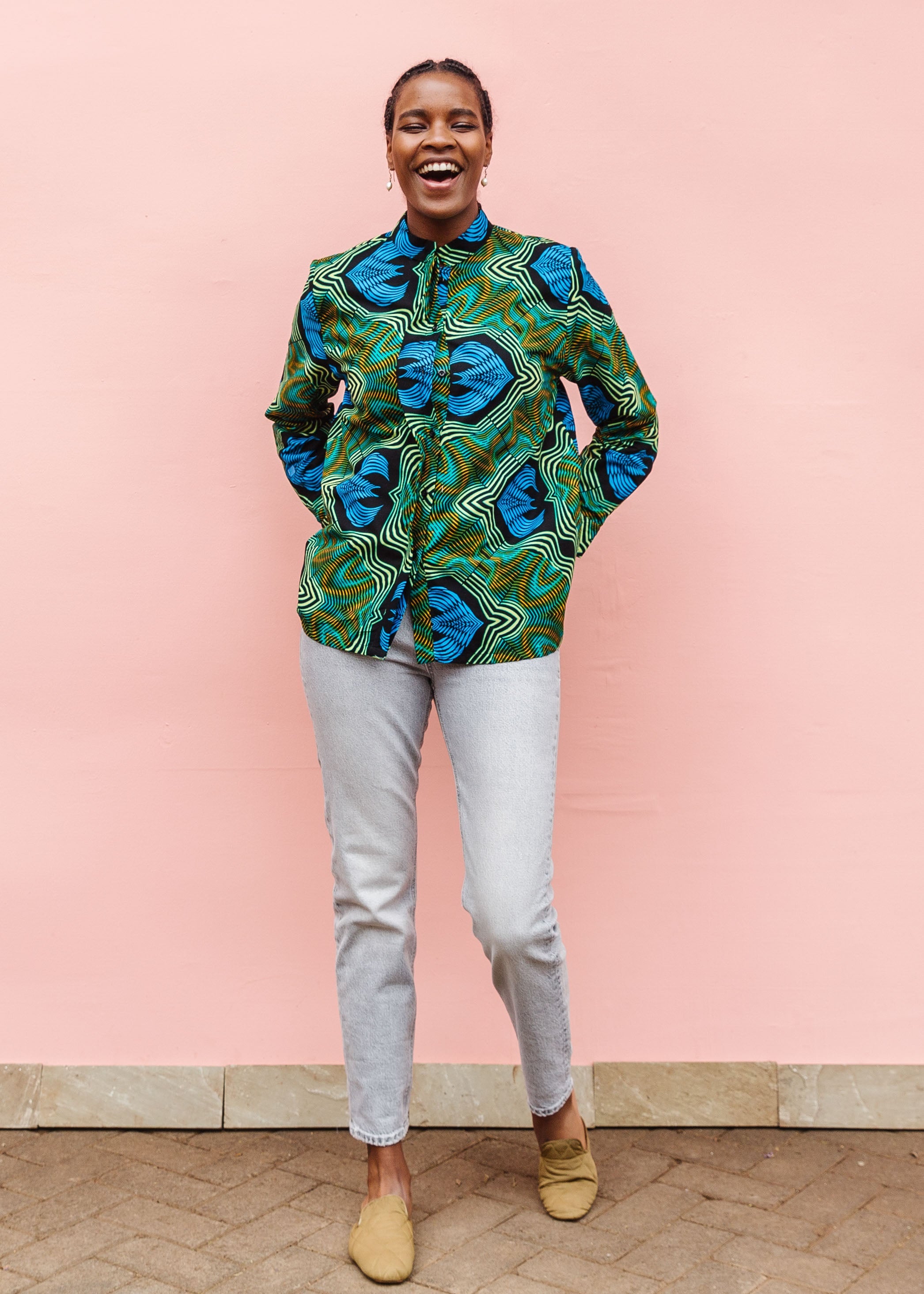 Model wearing long sleeve blouse with blue and green abstract vibration print.