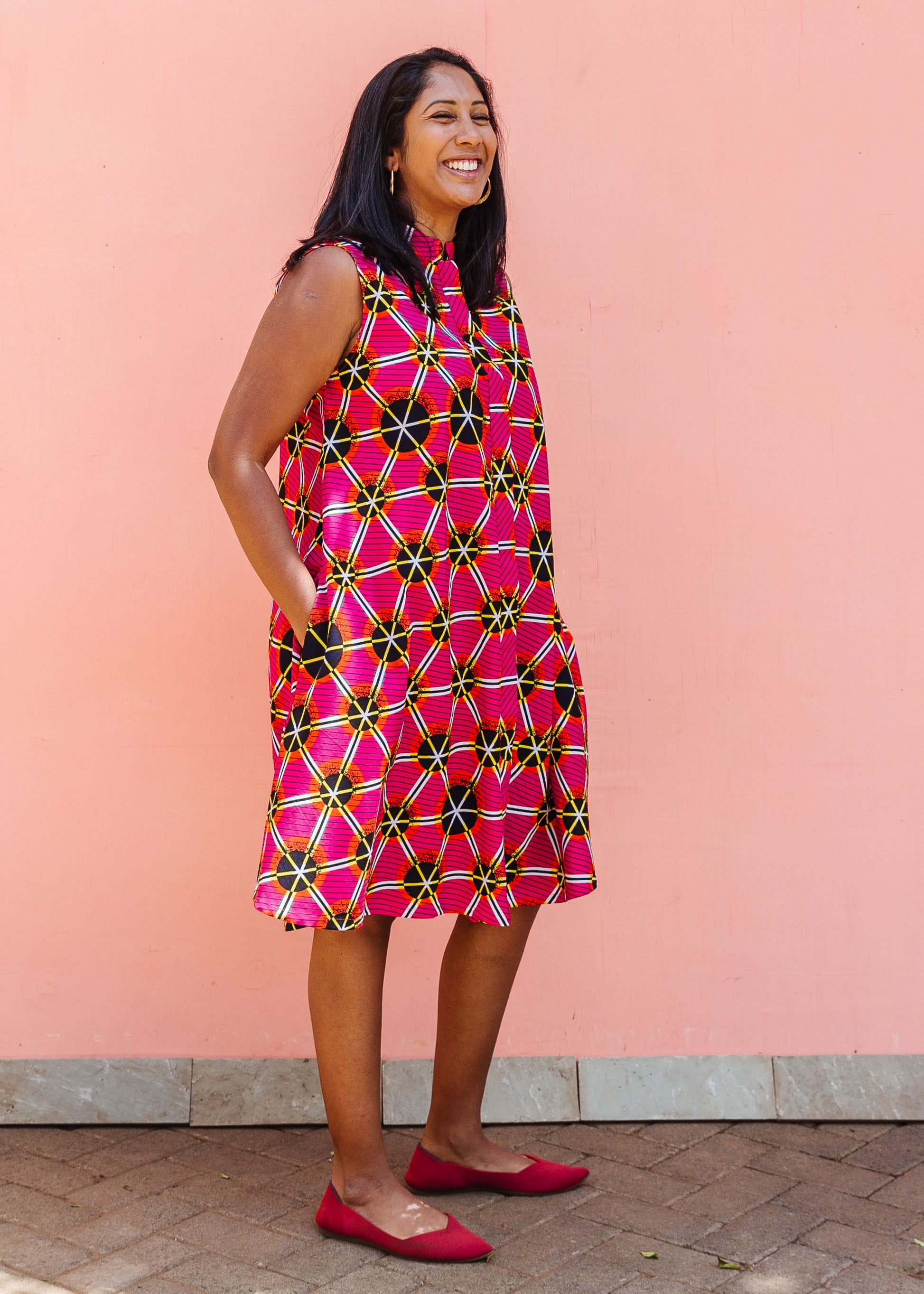 Model wearing sleeveless fuchsia dress with black dots and white and yellow lines.