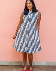 Model wearing white sleevless dress with black and white zigzag print.