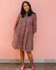 Model wearing red, navy and white mosaic print dress.