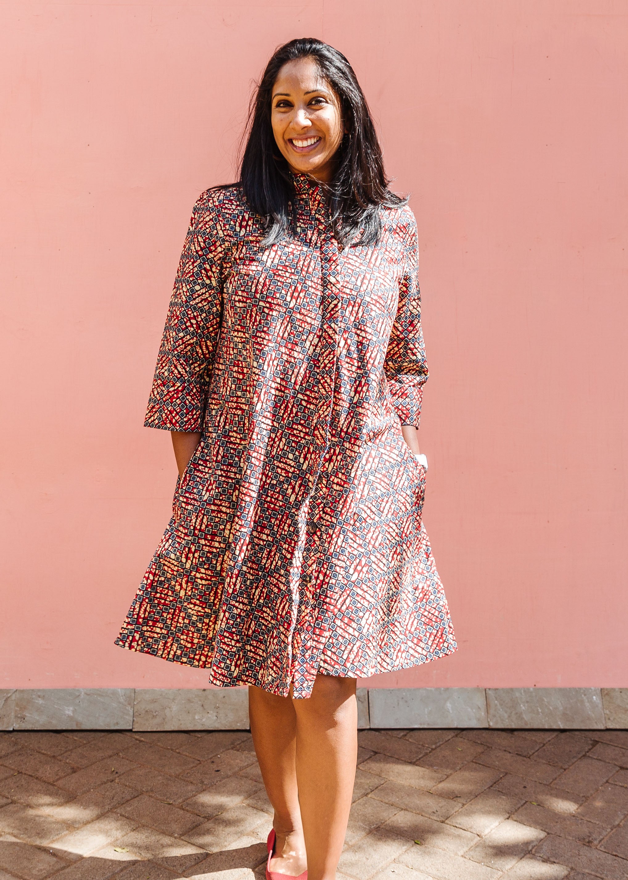 Model wearing red, navy and white mosaic print dress.