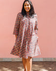 Model wearing red, navy and white mosaic print dress.