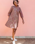 Model wearing red, navy and white mosaic print dress.