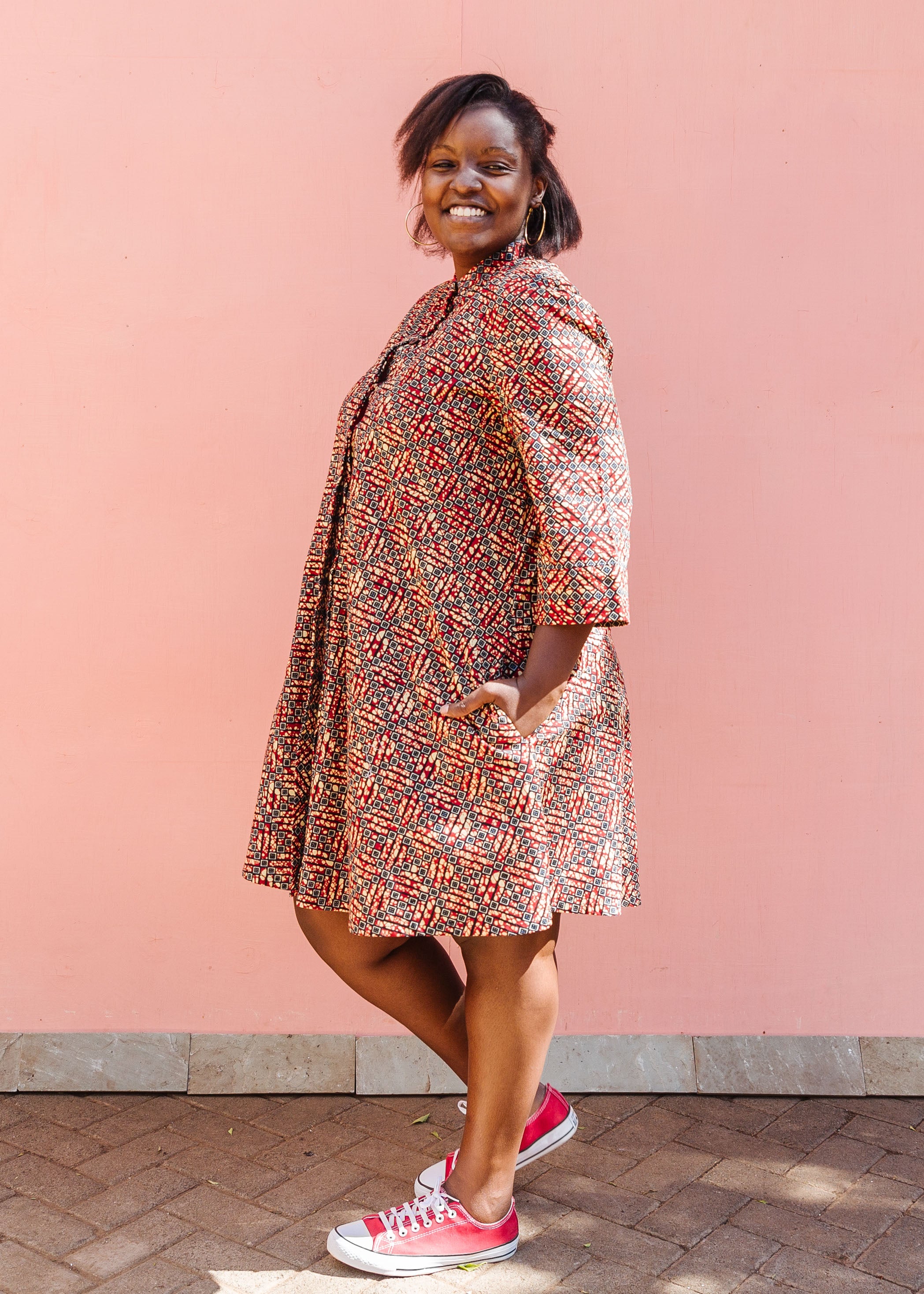 Model wearing red, navy and white mosaic print dress.