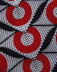 Close up display of white dress with red circles and black lines, fabric.
