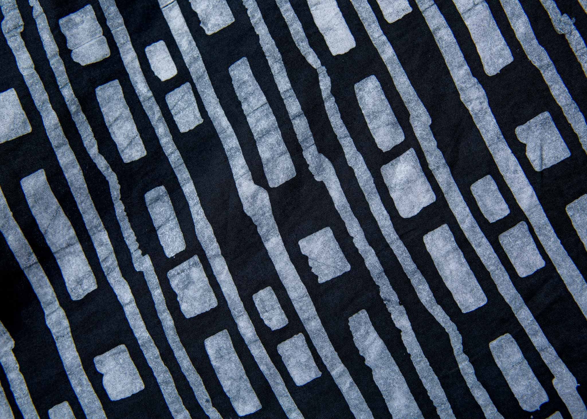Close up display of black dress with white lines print, fabric.
