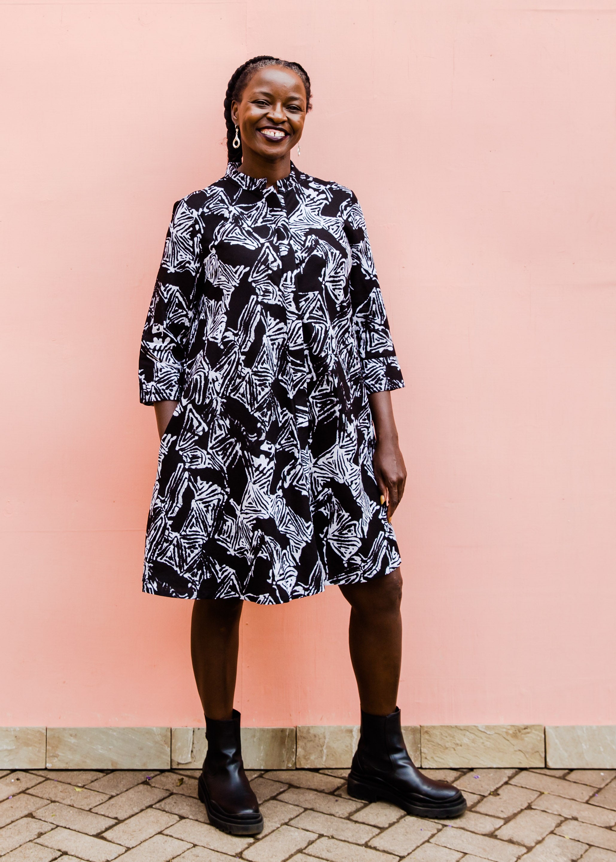 Model wearing black sketch print dress, paired with black boots.