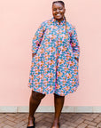 model wearing a lavender, blue and orange fiddlehead fern design dress