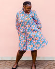 model wearing a lavender, blue and orange fiddlehead fern design dress