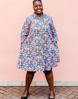 model wearing a lavender, blue and orange fiddlehead fern design dress