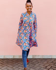 model wearing a lavender, blue and orange fiddlehead fern design dress