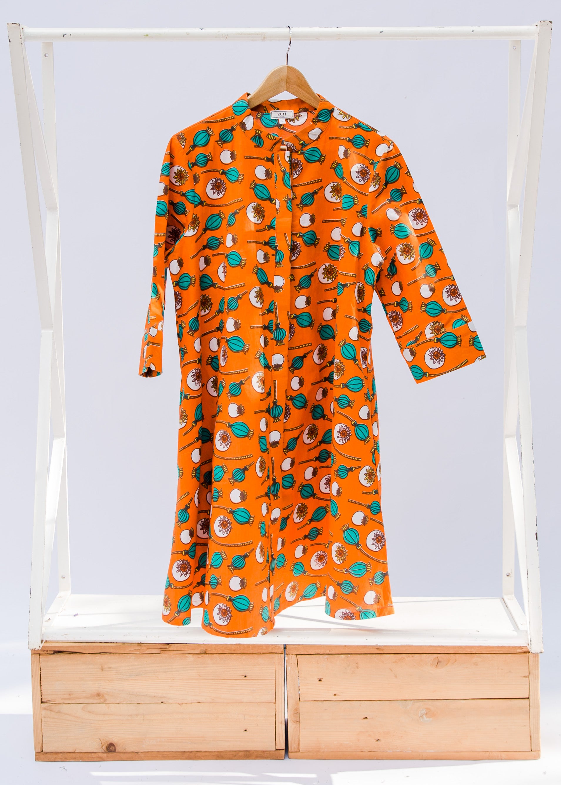 display of an orange, white and green plant design dress