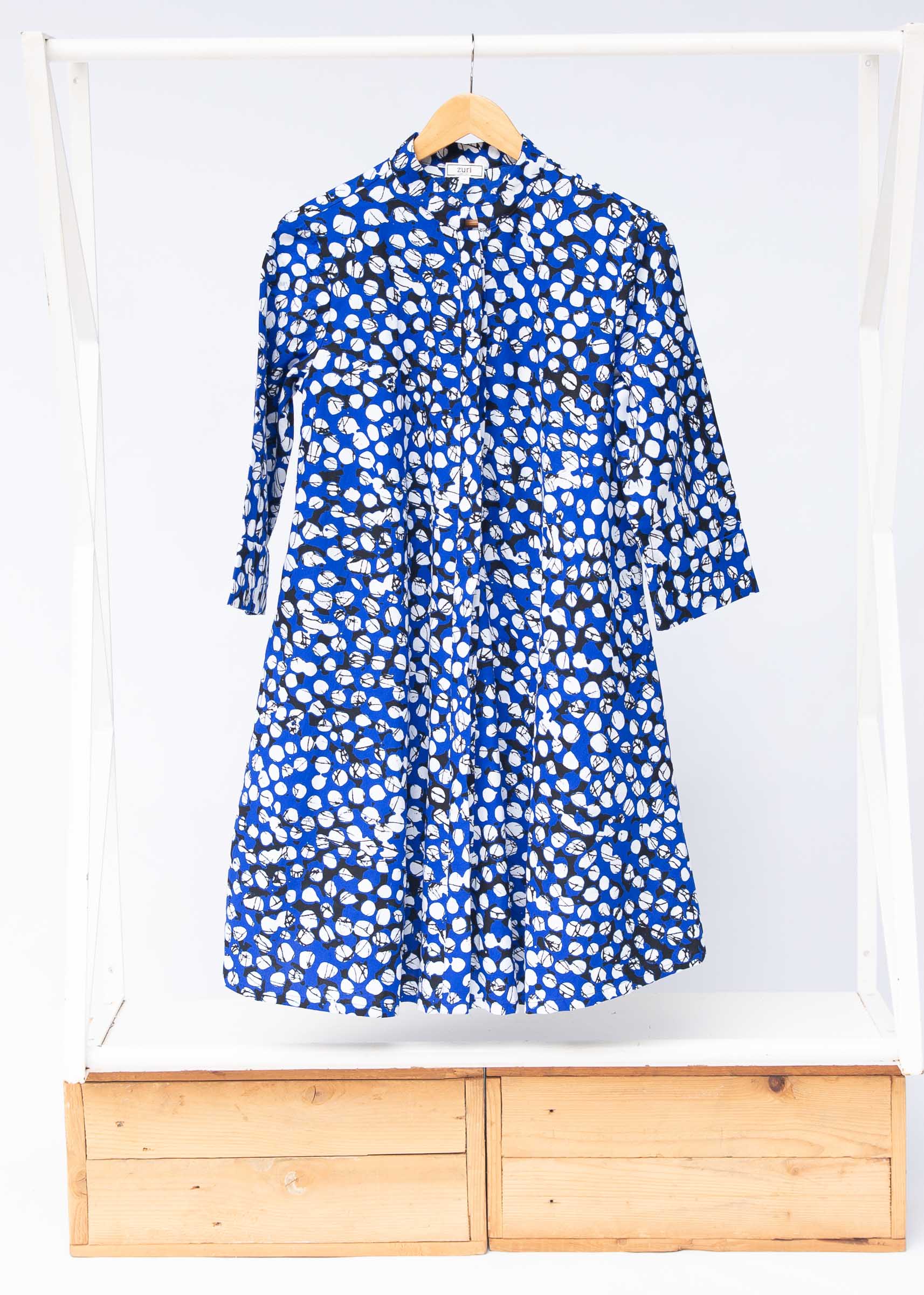 Display of blue dress with black and white abstract dots