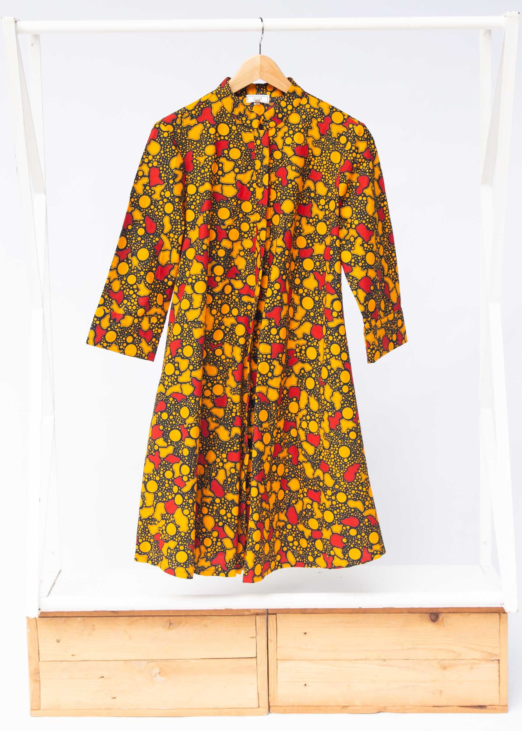 Display of black dress with yellow and red small blob print.