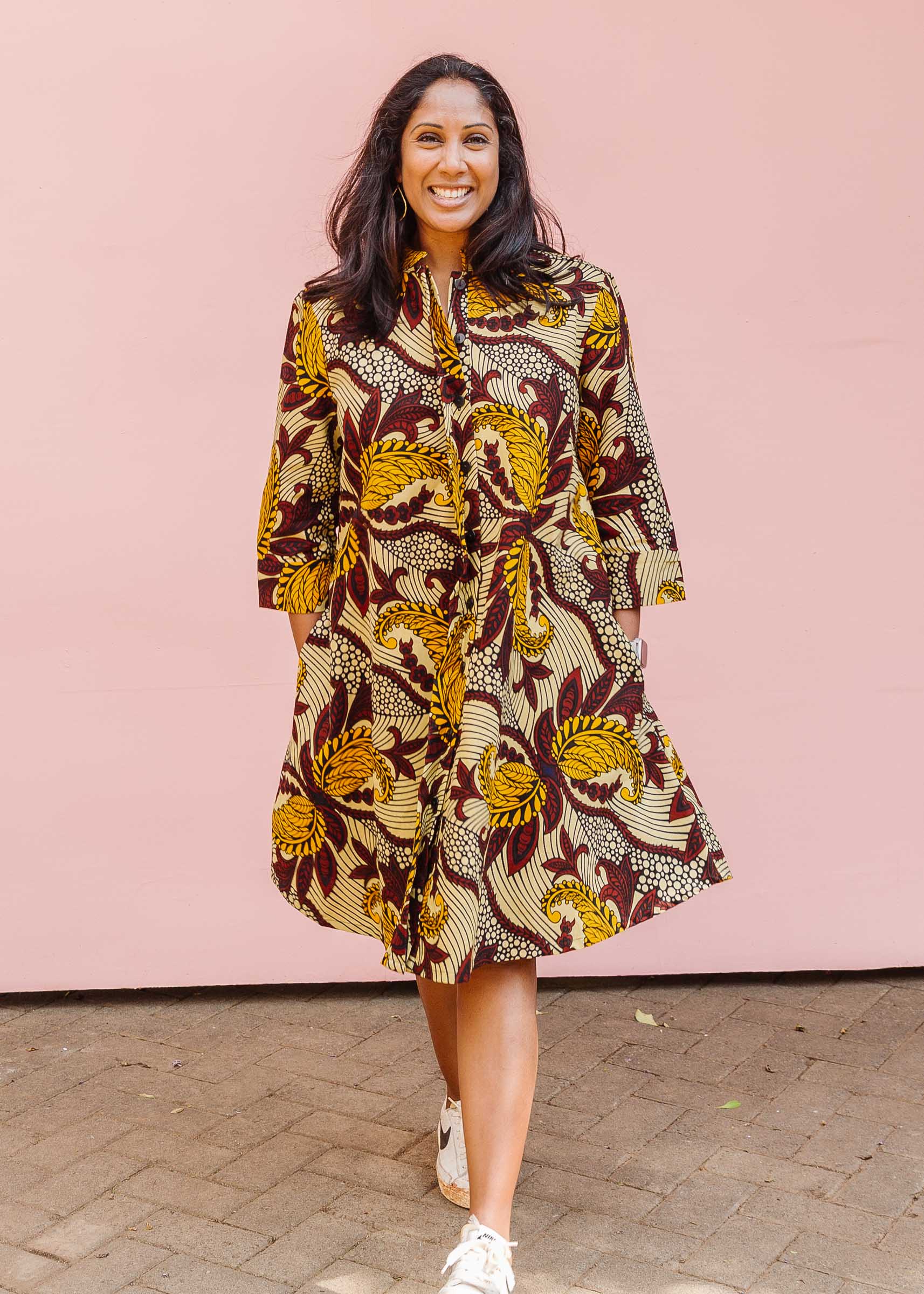 Model wearing paisley print dress with hues of brown.