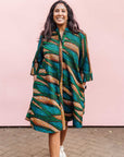 The model is wearing blue, green and orange abstract line dress.