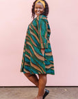 The model is wearing blue, green and orange abstract line dress.